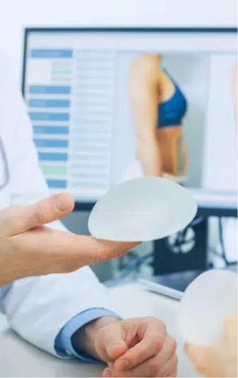 protesis-de-senos-mamoplastia Médico sosteniendo una prótesis de senos para realizar una mamoplastía