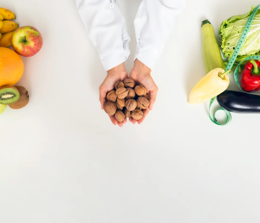 Una doctora muestra porciones de alimentos en una asesoría nutricional, con frutas, verduras y una cinta métrica. Una doctora muestra porciones de alimentos en una asesoría nutricional, con frutas, verduras y una cinta métrica.