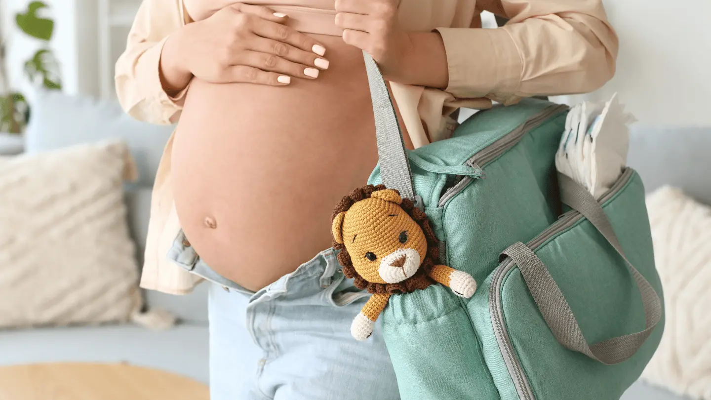 Mujer en trabajo de parto, lleva una maleta colgada al hombro para dirigirse al hospital para el nacimiento de su bebé.